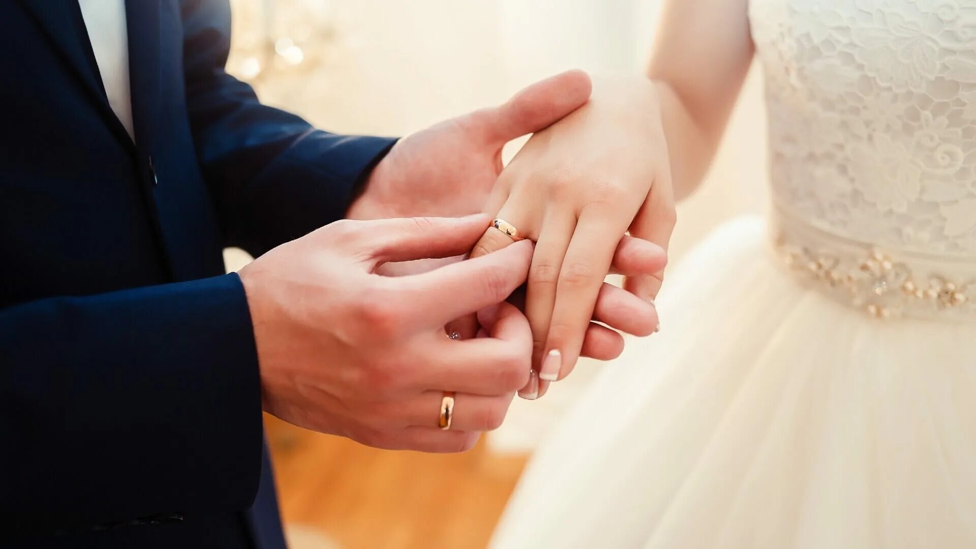 Надевает кольцо. Жених надевает кольцо невесте. Кольца жениха и невесты. Свадебные кольца на руках.