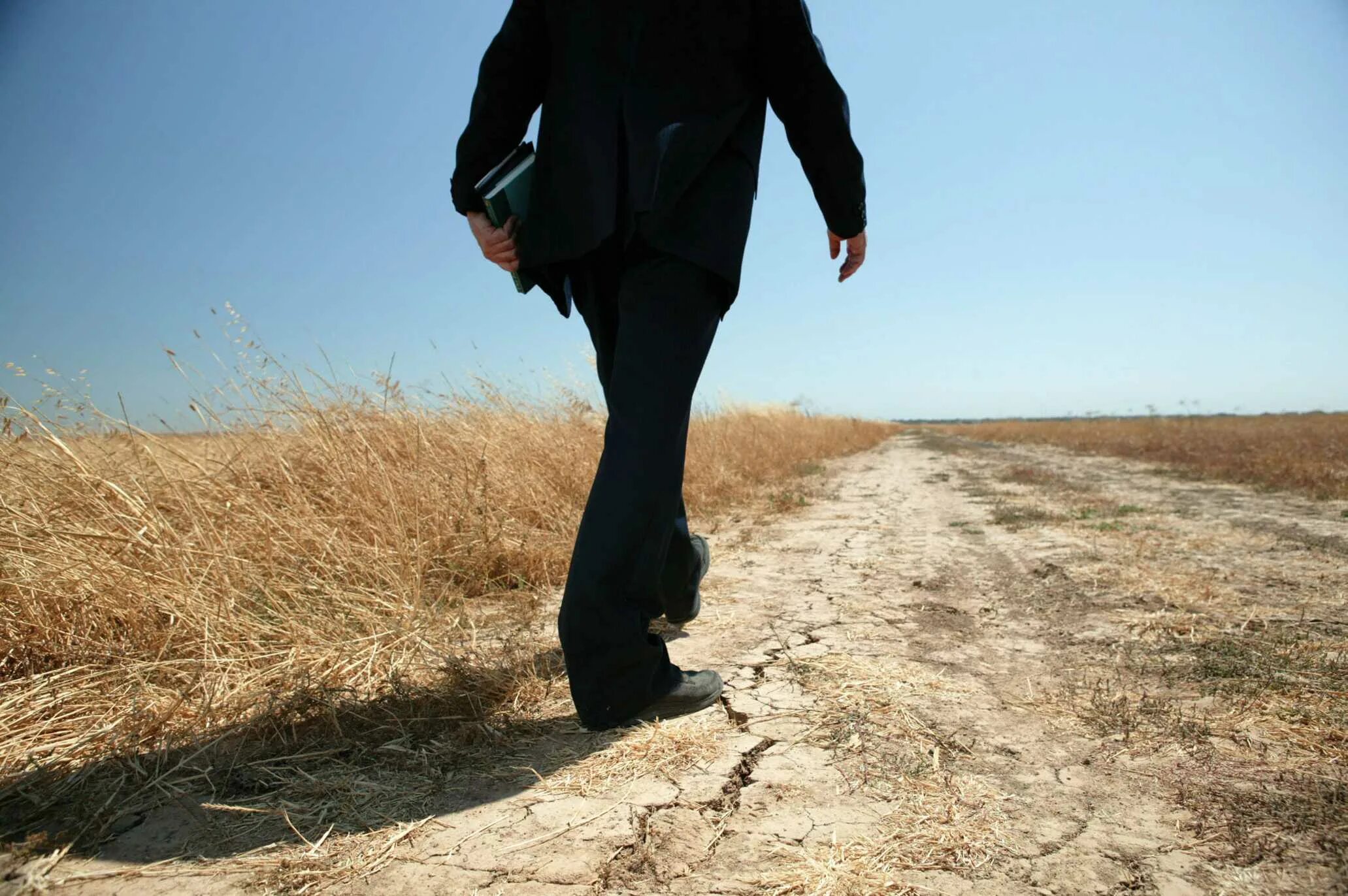 ноги идут. шагающего по дороге человека. человек идет вперед. ходьба ноги. уходит в закат.