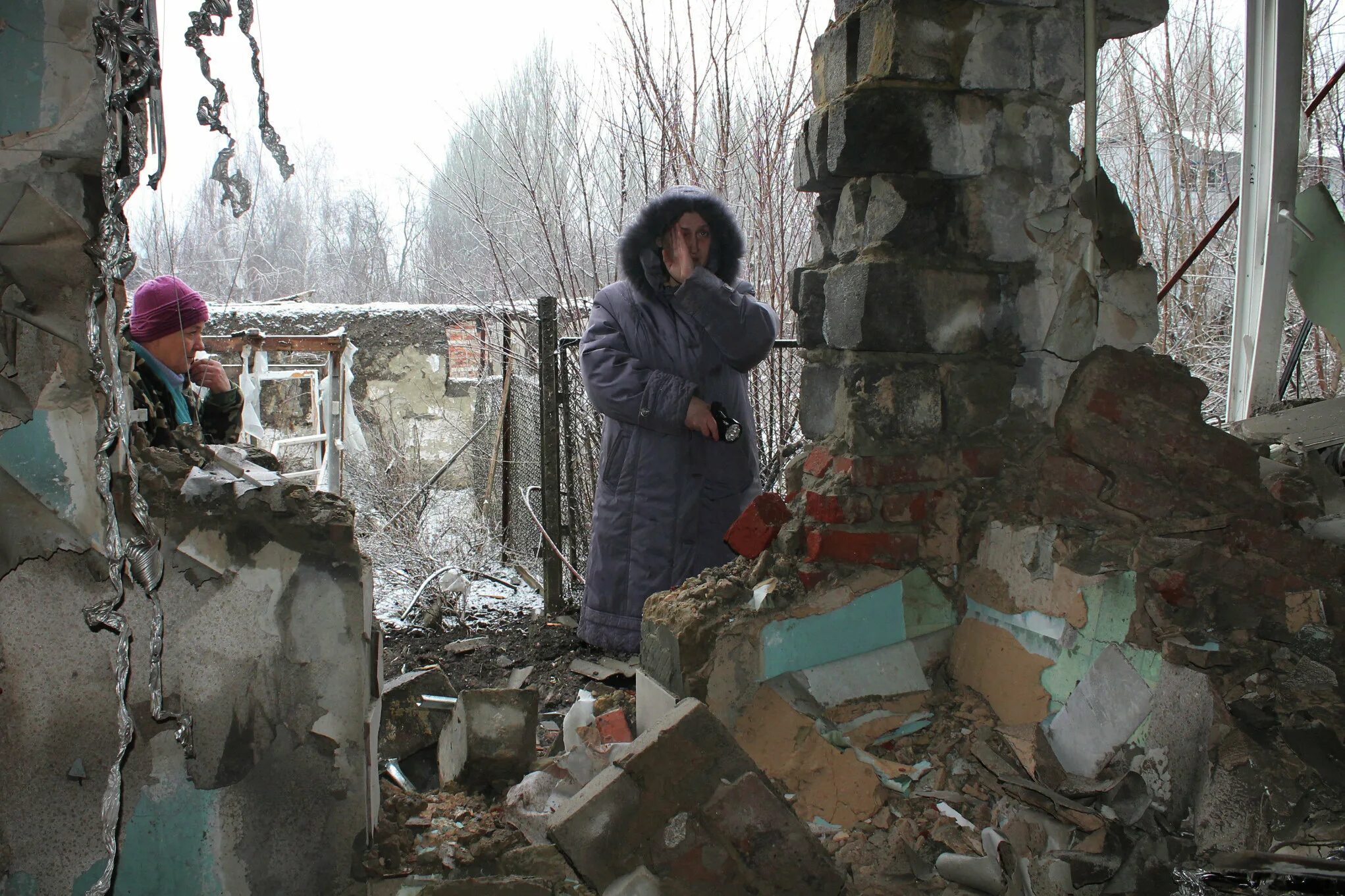 Сколько мирных жителей на донбассе. Донбас 2014 -2015 мирные жители. Беженцы Донбасса разрушенные здания. Чернухино обстрел. Человек на пороге разрушенного дома.