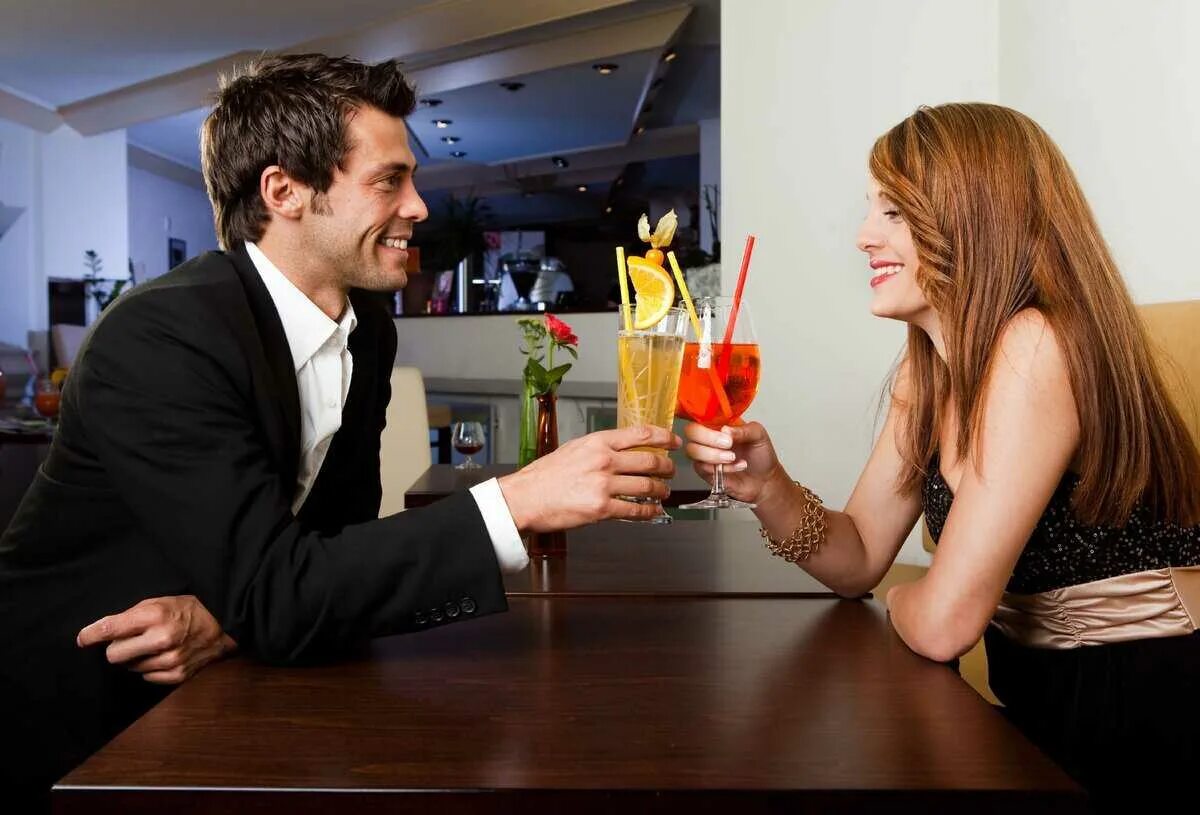 мужчина и женщина в кафе. дружеское свидание. парень дарит девушке подарок. парень и девушка в ресторане. первое свидание парня с девушкой.
