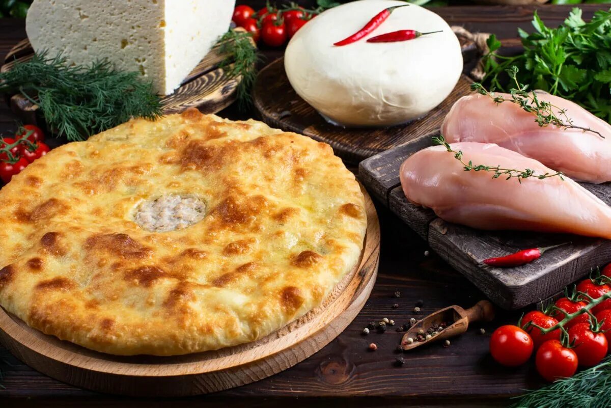 Выпечка осетинских пирогов. Осетинские хачапури. Осетинский пирог с картошкой рецепт на сковороде. Хачапури по-имеретински на круглой доске фото. Осетинский пирог с картошкой рецепт на сковороде.