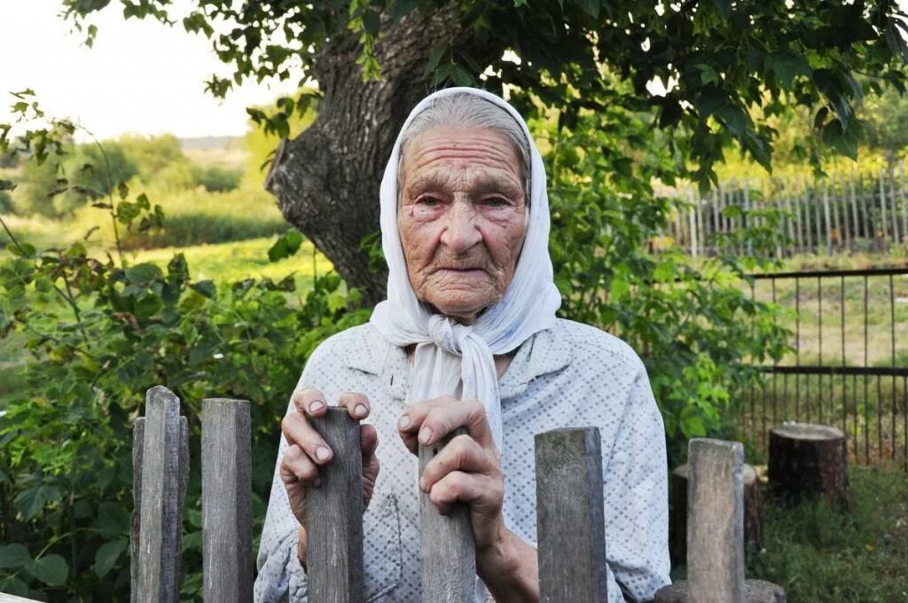 Деревенская бабушка. Старушка в деревне. Старушка у забора. Пенсионеры в деревне.