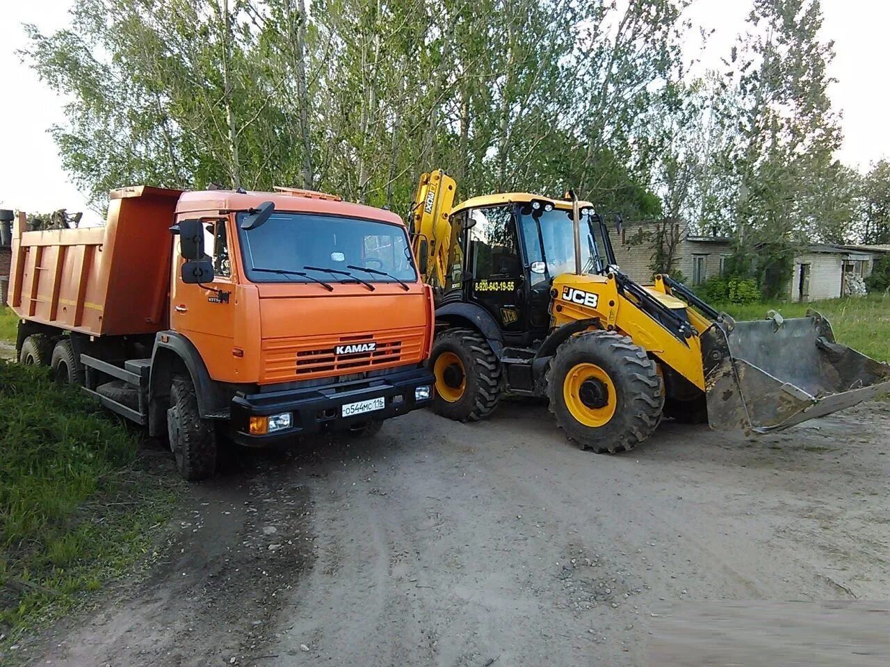 Трактора грузят. Трактор JCB грузит КАМАЗ. КАМАЗ 65115 JCB. Трактор копает песок КАМАЗ.