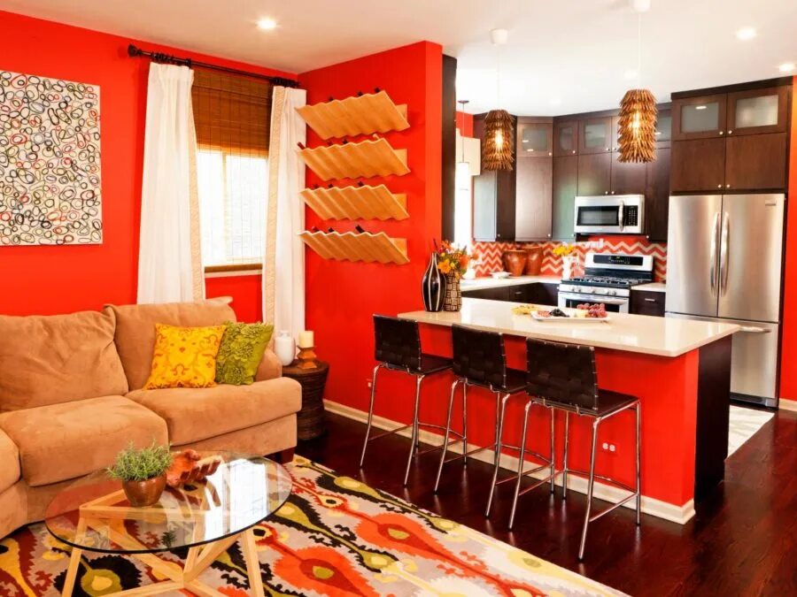 Купить студию в красном. Яркий интерьер кухни-гостиной. Оранжевые стены в интерьере. Яркая кухня гостиная. Интерьер гостиной с оранжевой кухней.