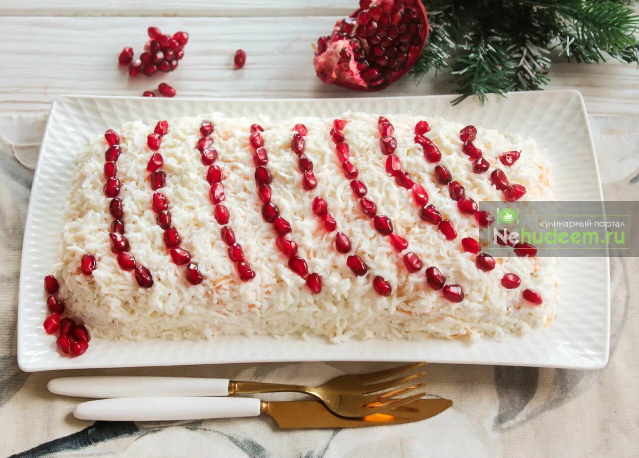 салат гранатовые бусы на снегу. салат украшенный гранатовыми зернами. салат бусы на снегу на новый год.