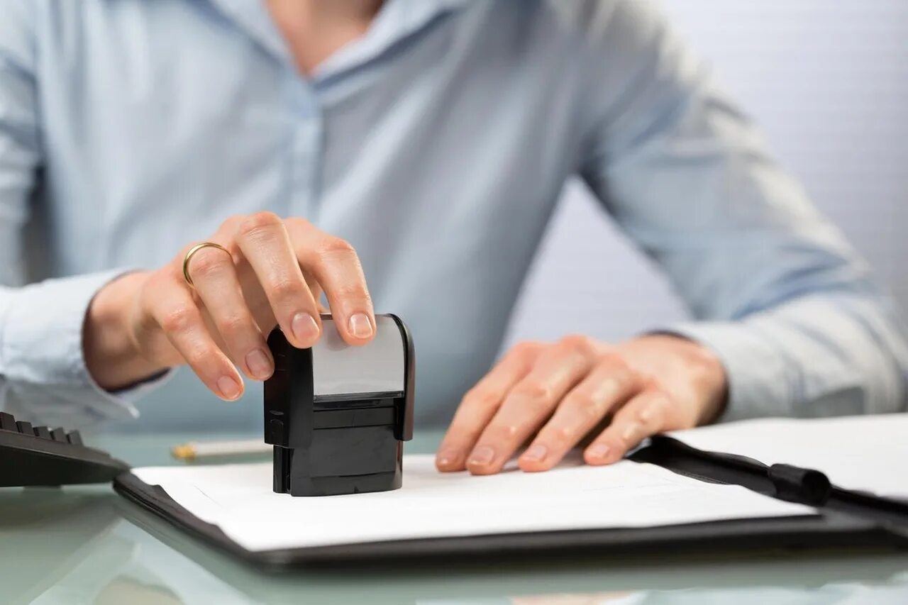 Ставит печать. Человек ставит печать. Печать для документов. Регистрация предприятия. Человек ставит печать.