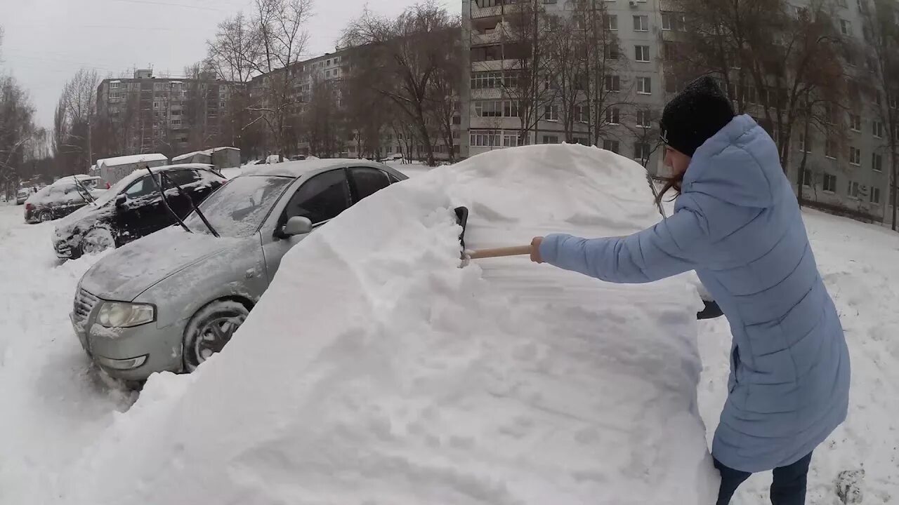 Откопала или откапала. Откапывает машину. Раскапывать машину из снега. Машина в сугробе. Откапывает машину от снега.