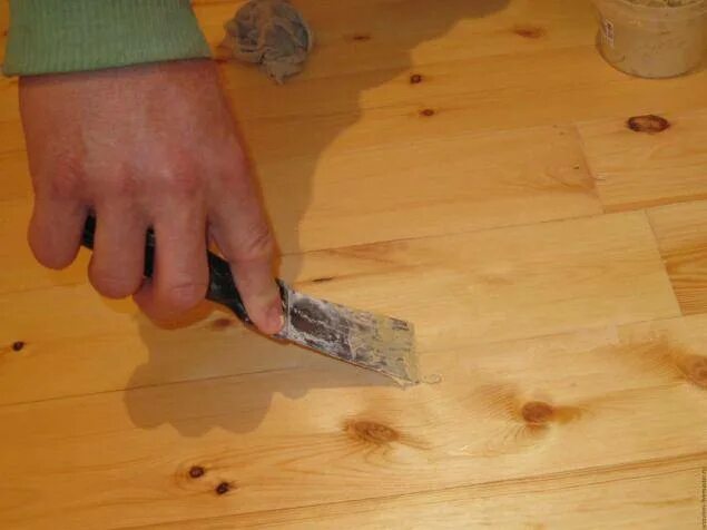 Зашпаклевать трещины. Щели в деревянных полах. Шпатлевание дефектов древесины. Шпаклевка для заделки щелей в деревянном полу. Шпаклевка для трещин в дереве.