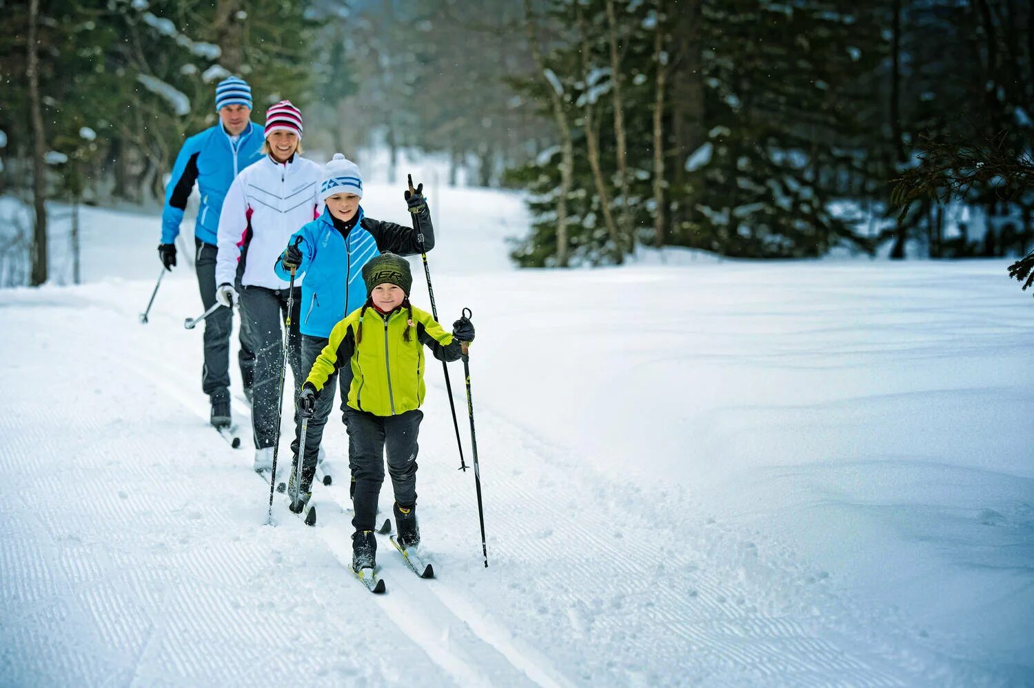 Спорт в год семьи. Семья катается на лыжах. Прогулка на лыжах. Катание на лыжах в лесу. Спорт зимой.