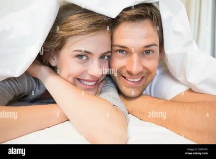 Happy couple under the duvet Stock Photo - Alamy.