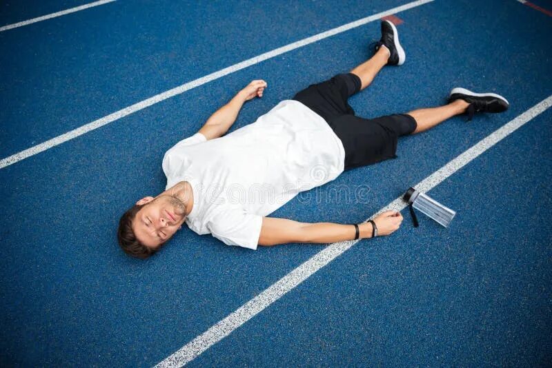 Уставший спортсмен. Спортсмен лежит. Спортсмен лежит на полу. Спортсмен валяется.