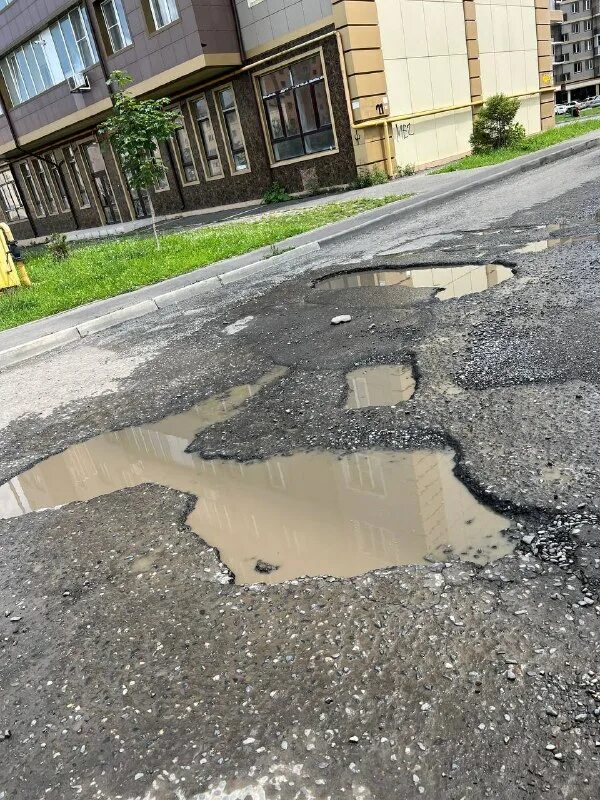яма на дороге. некрасивые дороги. плохие дороги. ямы на дорогах лужи. яма образовалась на новом тротуаре в чите.