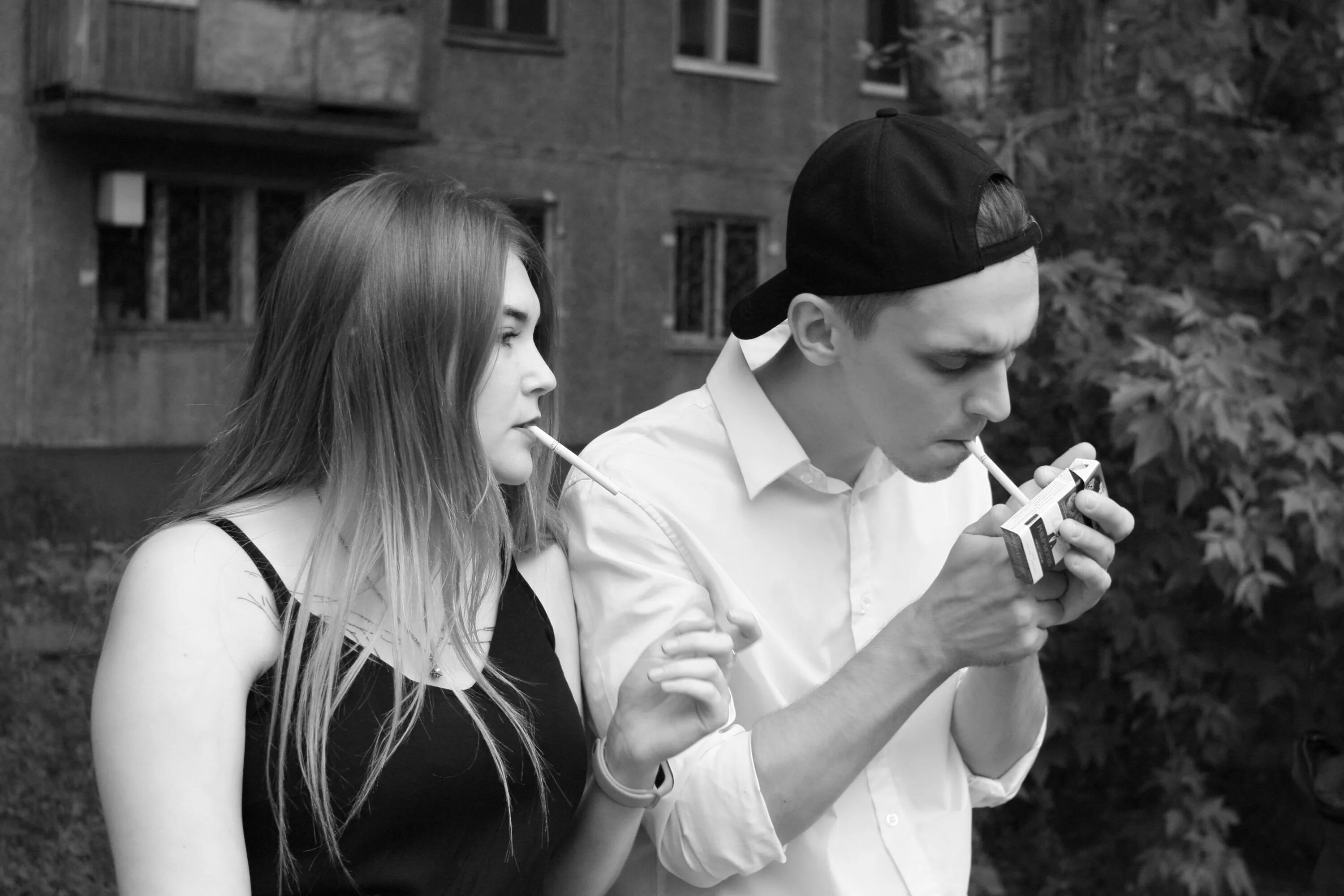 Курим на пополам. Курящие парень и девушка. Парень с девушкой курят сигарету. Парень прикуривает сигарету. Парень и девушка с сигаретой.