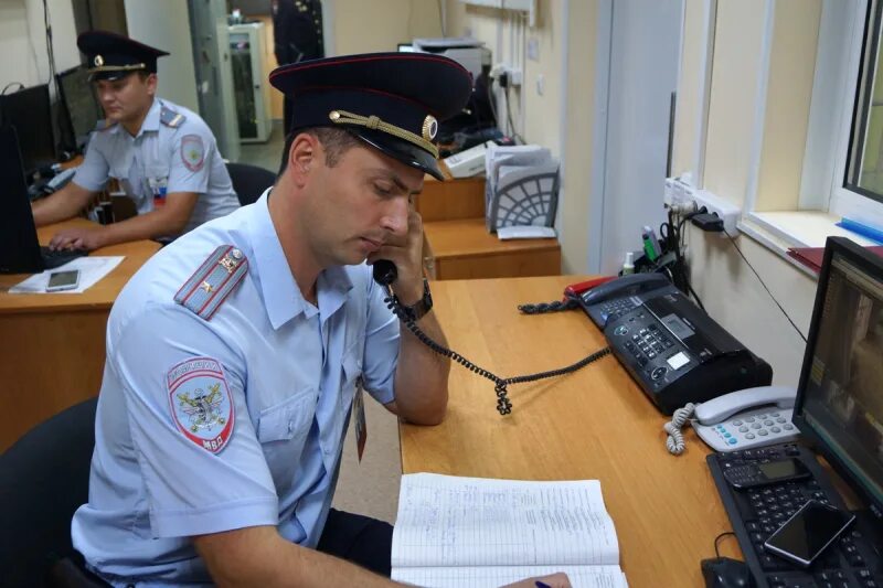 Дежурный отдела полиции. Дежурный полицейский. дежурная часть полиции. сотрудники дежурной части полиции. полицейский за столом.
