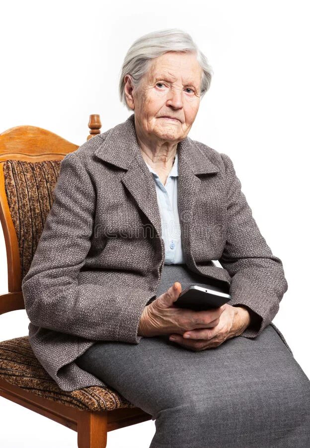 В скромно обставленном кабинете сидел пожилой человек. Пожилая женщина сидит. Сидячая пожилая женщина. Старушка сидит на стуле. Пожилая женщина по пояс.