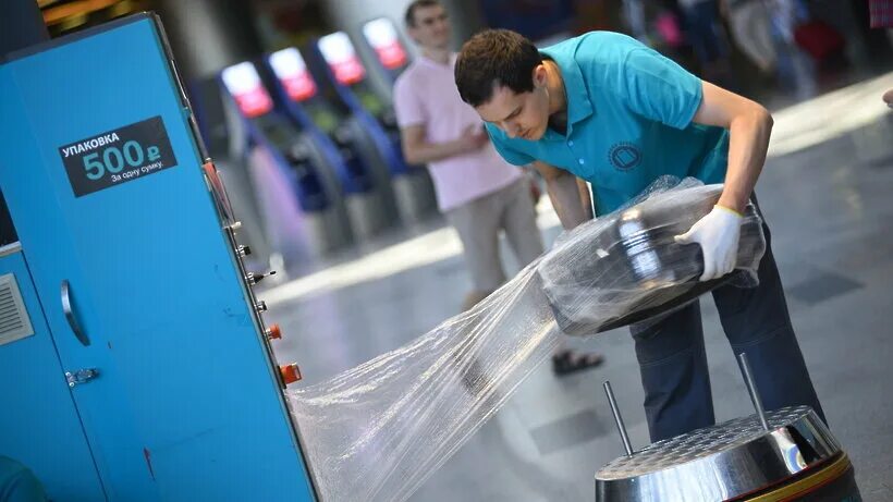 Машинка для упаковки багажа. Упаковка багажа. Аэропорт фергана упаковка багажа. Упаковка багажа в пулково. Упаковка чемоданов в аэропорту.