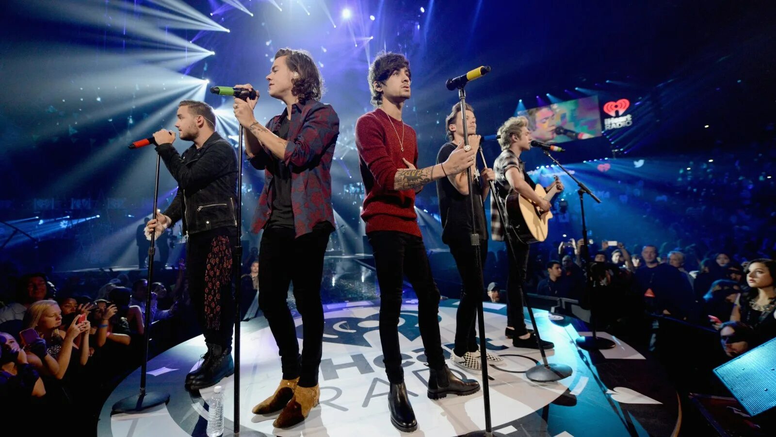 Много людей поют. One Direction на сцене. One Direction поют на сцене. Человек поет на сцене. Много людей на сцене поют.