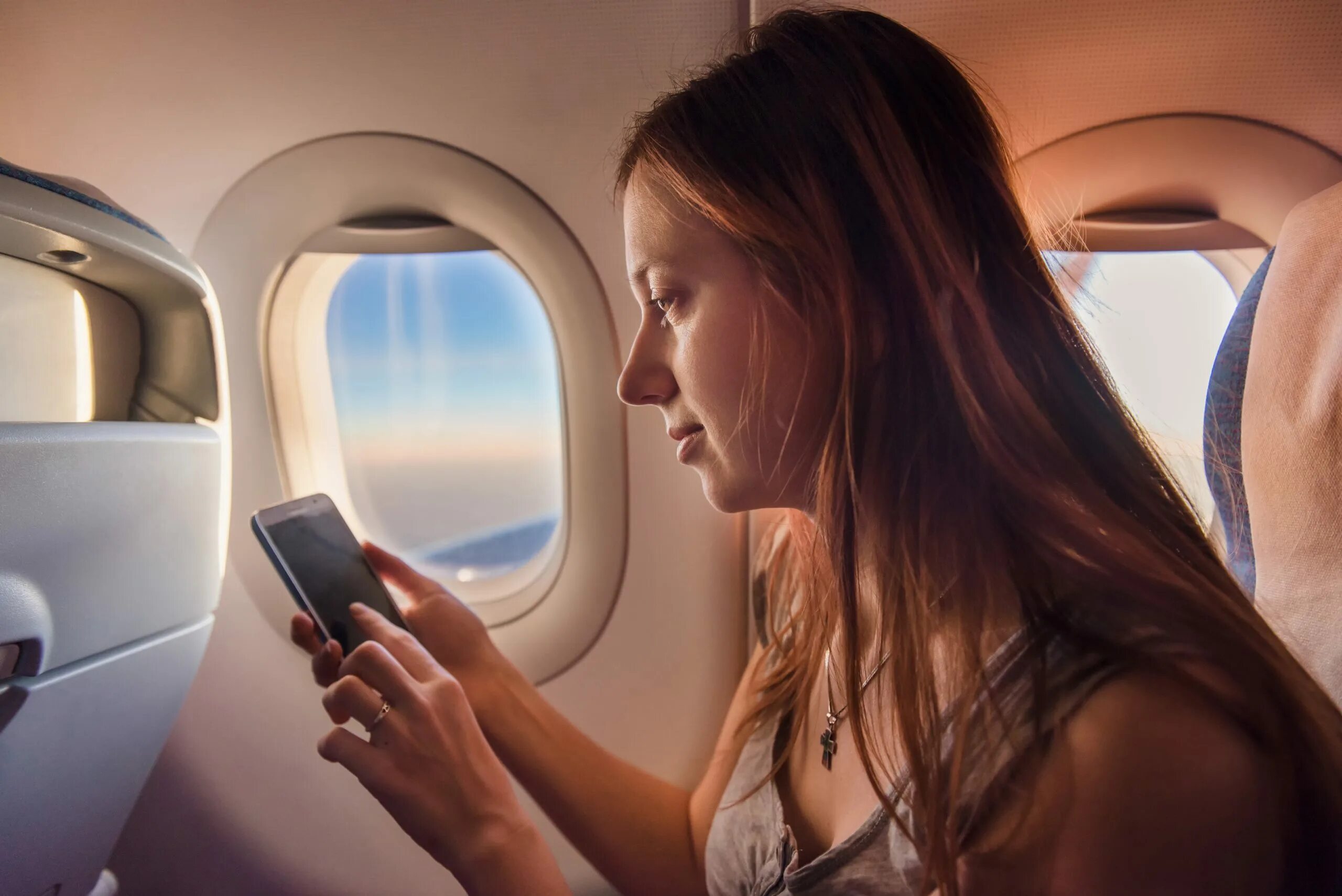 Airplane mode phone. Дают ли наушники в самолете. Забыли телефон в самолете. В самолёте с мобильным телефоном. Человек сидит в самолете.