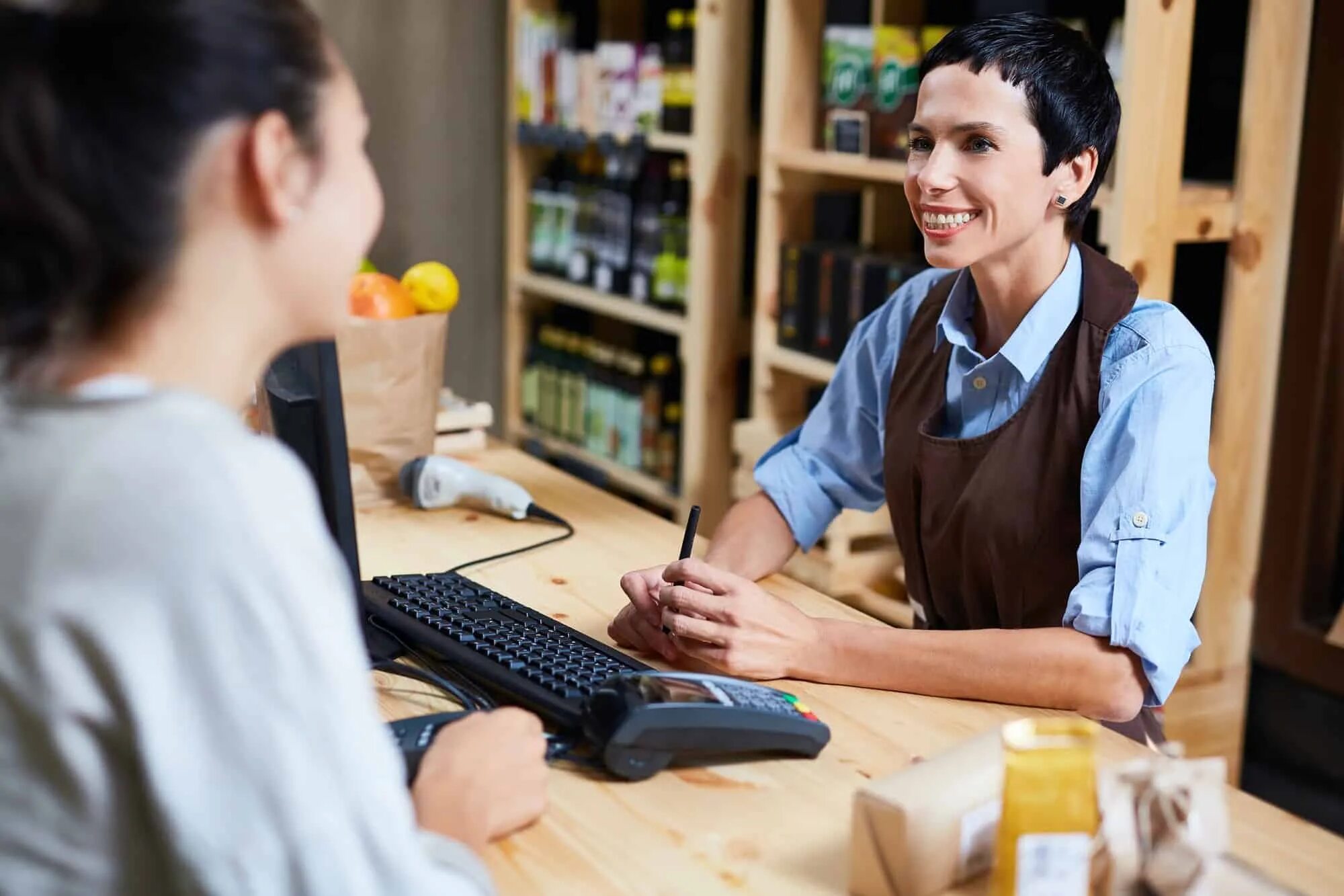 She is a shop assistant. Продавец улыбается. Продавец с клиентом разговаривают иллюстрация. Общение с продавцом картинки. Продавец общается с клиентом.