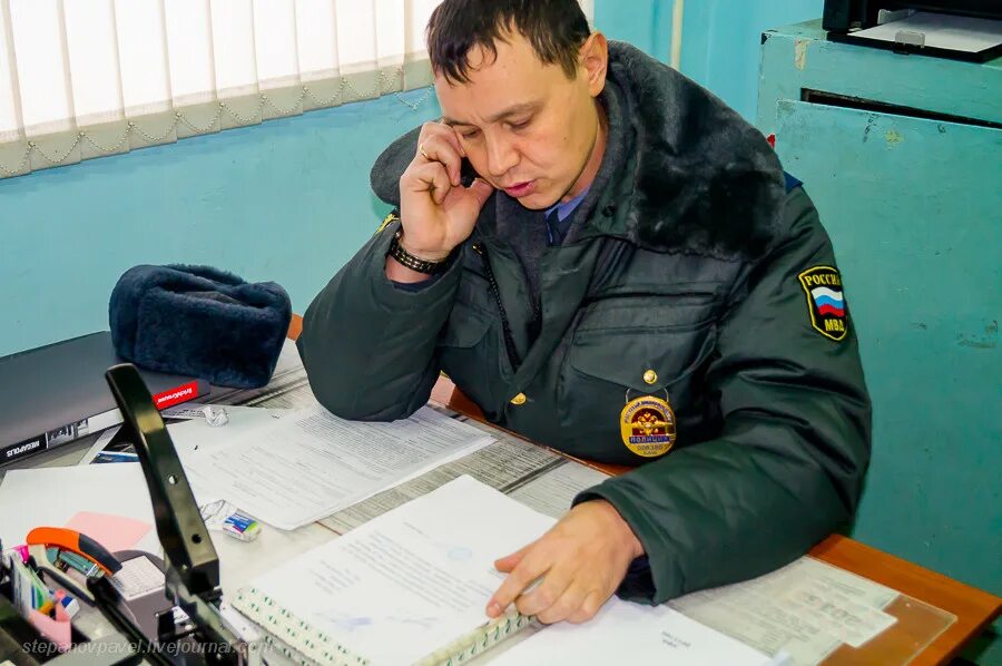 Милиционер в кабинете. Полицейский участок. Полицейский с бумажкой. Полицейский за столом. Участковый угрожает