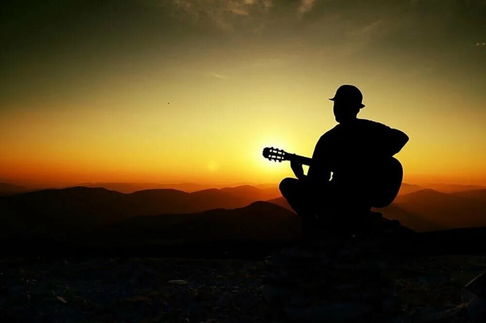 Душевные песни мужчине. Гитарист на закате. Человек с гитарой на закате. Гитара закат. Тень человека с гитарой.