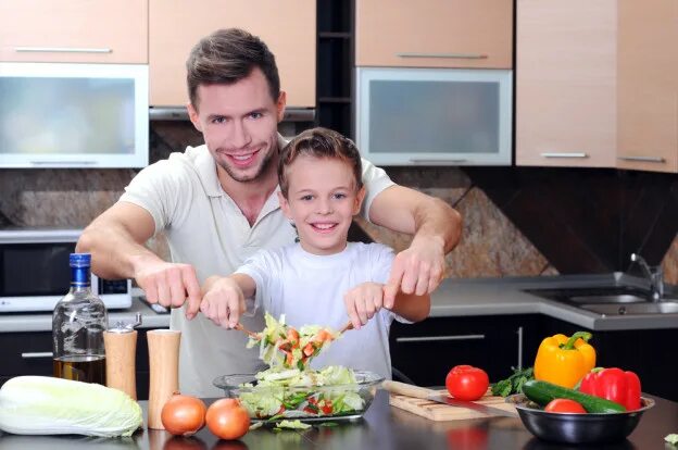 Дочки дают отцам на кухне после приготовления пищи