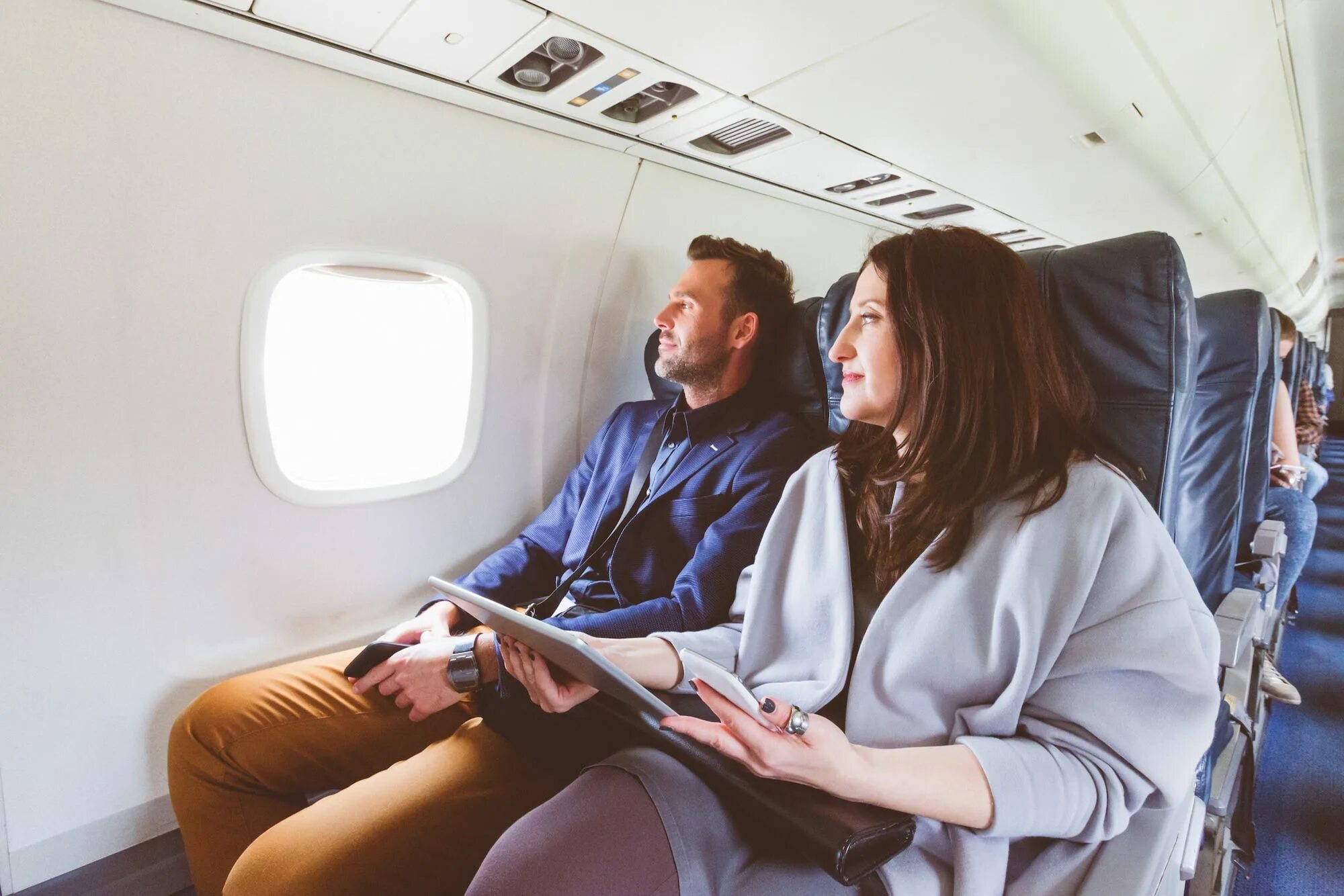 The plane showed the passengers. Пара в самолете. Мужчина и женщина в самолете. Путешествие на самолете. Девушка в самолете.