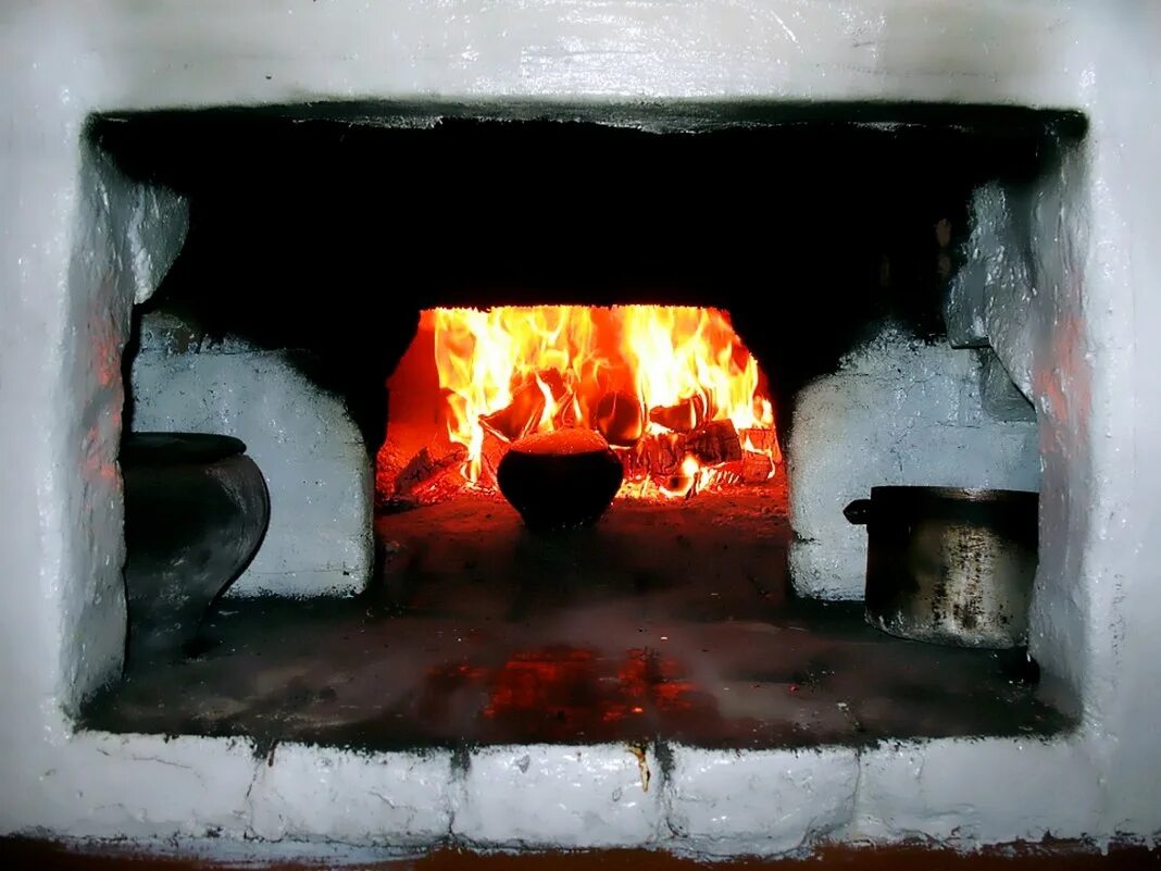 Печка старинная. Кидает дрова в печь. Топка русской печи. Русская печь топится. Печь зимой.