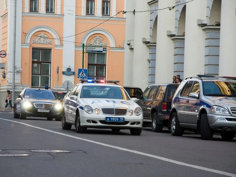 Гуф иномарка с мигалками поворачивает в арку. Служебный автомобиль. Полицейская машина сопровождения. Машины с мигалками. Сопровождение машинами ГИБДД.