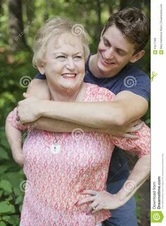 Подросток обнимая усмехаясь старшую женщину 