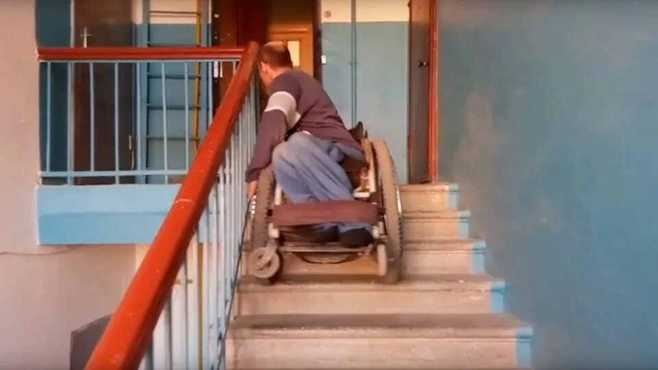 Больно подниматься по лестнице. Спуск инвалидной коляски по лестнице. Инвалидная коляска для лестницы. Инвалид упал с лестницы. Коляска для спуска инвалидов по ступенькам.