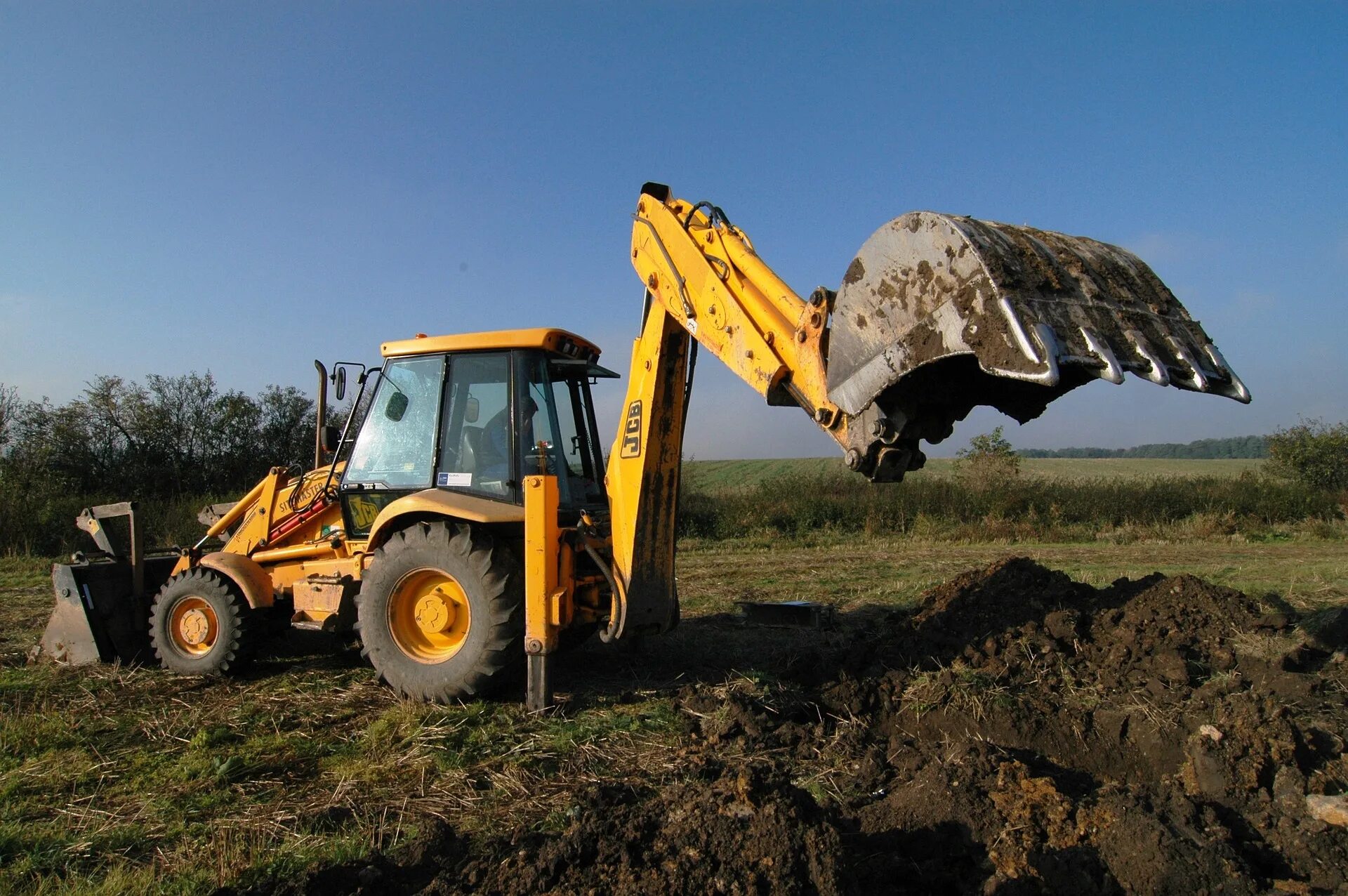 Покажи работающий экскаватор. Экскаватор-погрузчик jcb копает. трактор-экскаватор 702621. трактор с ковшом jcb настоящий. ковш экскаватора.