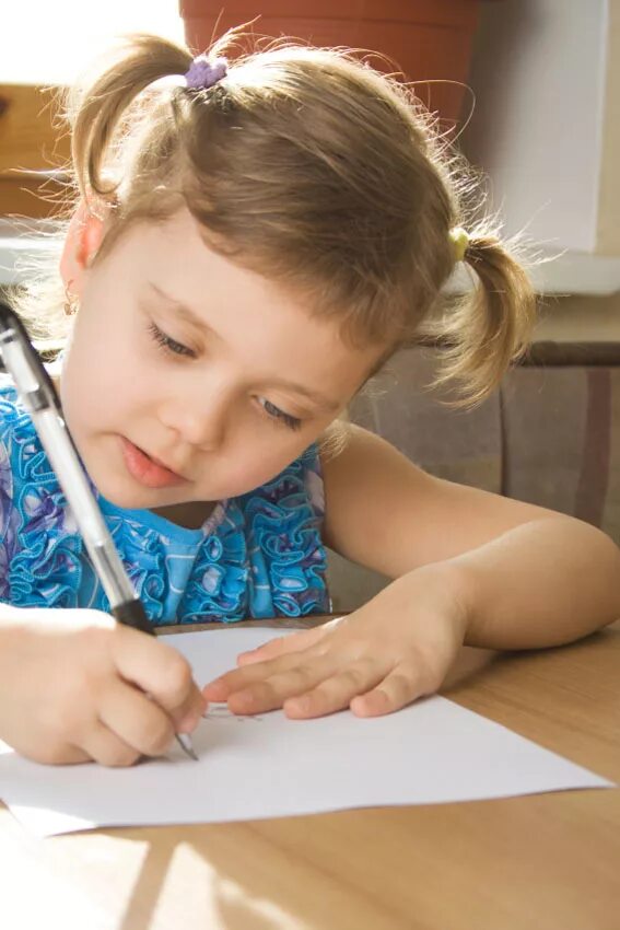 Ребенок пишет. Ребенок учится писать. Дети учатся. Девочка пишет письмо.