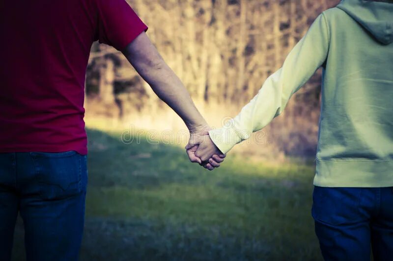 Мальчик держит девочку за руку. Держит за руку. Гулять за ручку. Девушка и мальчик в тени. Идут за руку.