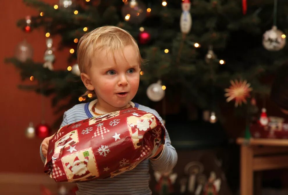 дети наряжают елку. новогодний праздник для детей. рождество в англии семья. семья наряжает елку. традиции нового года.