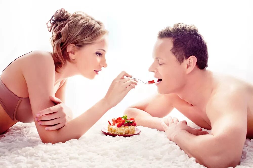 мужчина дарит шоколад. парень кормит девушку шоколадом. мужчина и женщина завтракают. парень девушка и клубника. мужик с клубникой.