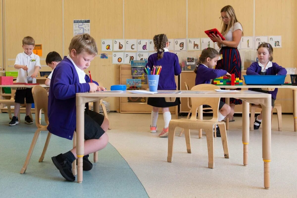 The pupils are in the classroom. Primary school in england. primary school reception classes. pupils in class. primary school classroom.