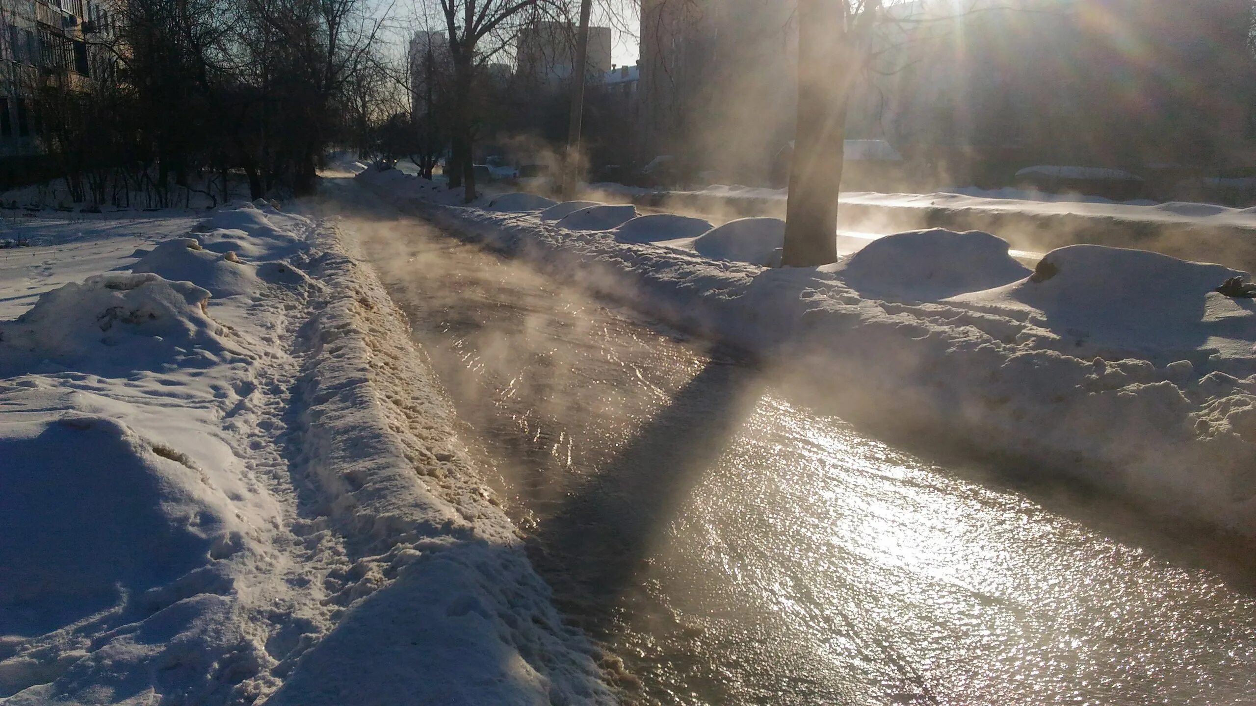 Снег весной на дороге. Таяние снега в городе. Весенние ручьи.