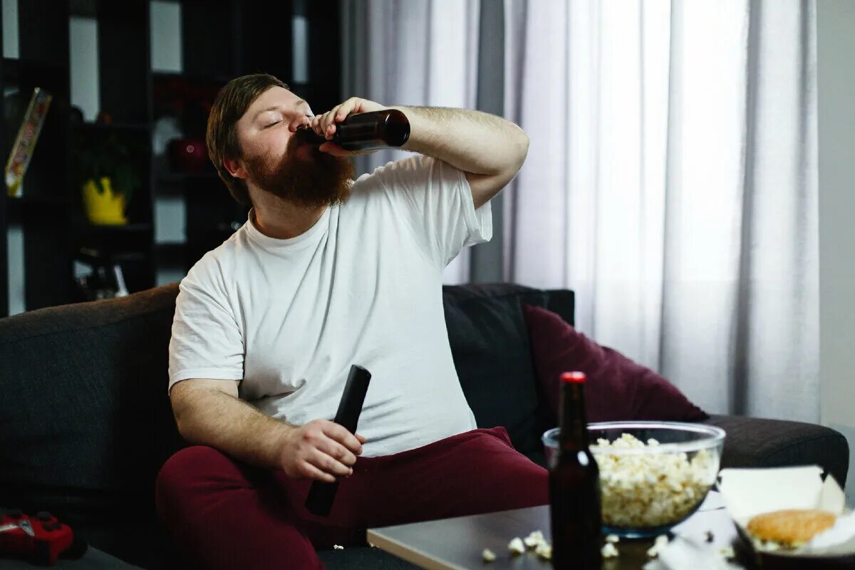 Мужчина на диване с пивом. Мужик пьет пиво на диване. Мужик лежит на диване с пивом. Пиво перед телевизором.