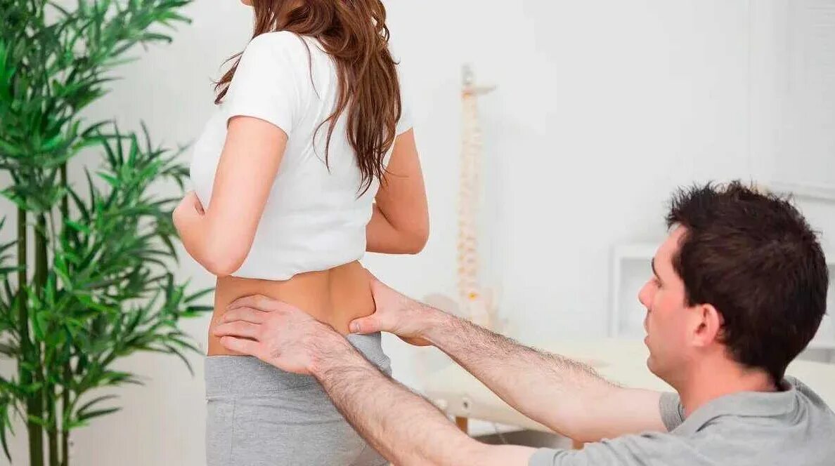 Девушка держится за живот. Девушка с больной спиной. Болит спина женщина в офисе. Больно сидеть женщины. Левушка сидит на коленях.