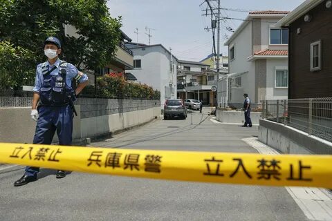 A police office stands guard near the house where two women were killed by ...