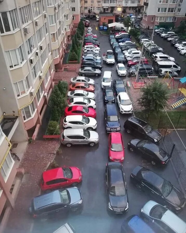 Стихийная парковка во дворе. Стихийная парковка во дворе. Парковка во дворе. Стоянка машин. Много машин во дворе.