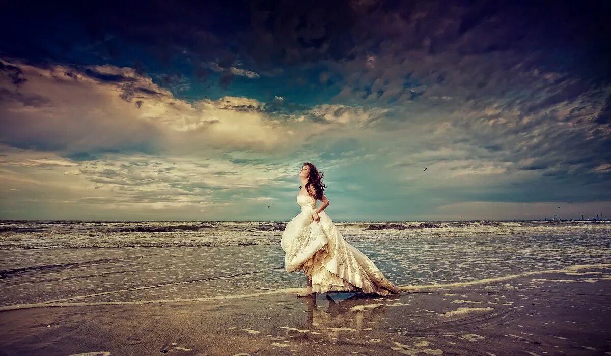 Девушка на берегу. Девушка в белом платье на берегу моря. Девушка в белом платье. Девушка на берегу моря. Женщина идет по берегу