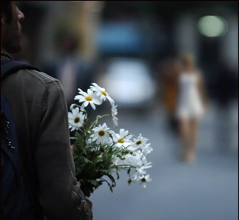 Цветы за спиной. Девушке дарят цветы. Дарит цветы со спины. Юноша дарит цветы. На улице дарят цветы