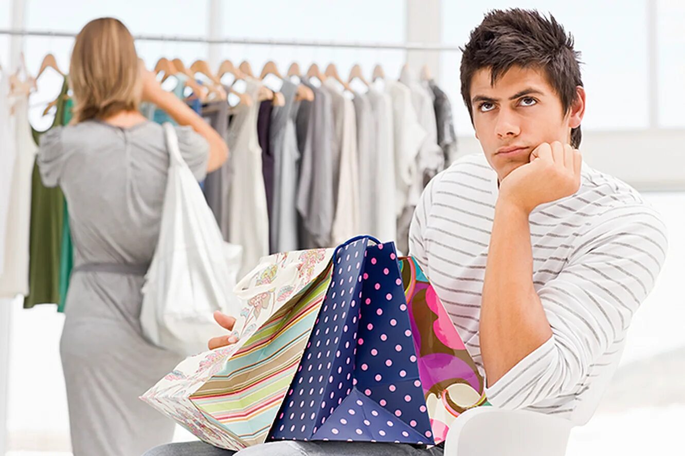 Выбирая покупку или расплачиваясь сумку. Человек выбирает одежду. Мужчина шоппинг. Мужская и женская одежда шопинг. Мужчина и женщина в магазине.