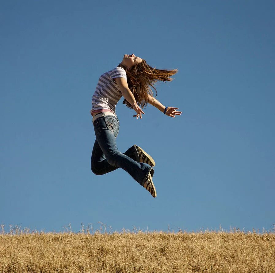 Девушка хохочет. Человек, который смеется. Летающий человек. Девушка прыгает в воздухе. Девушка смеется.