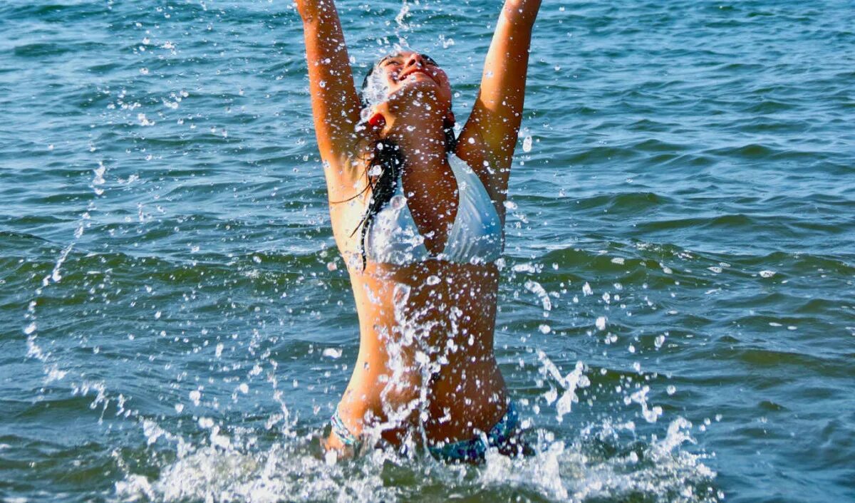 Вода в море прогревается. Купание в море. купаться в море. девушка купается в море. люди купаются в море.