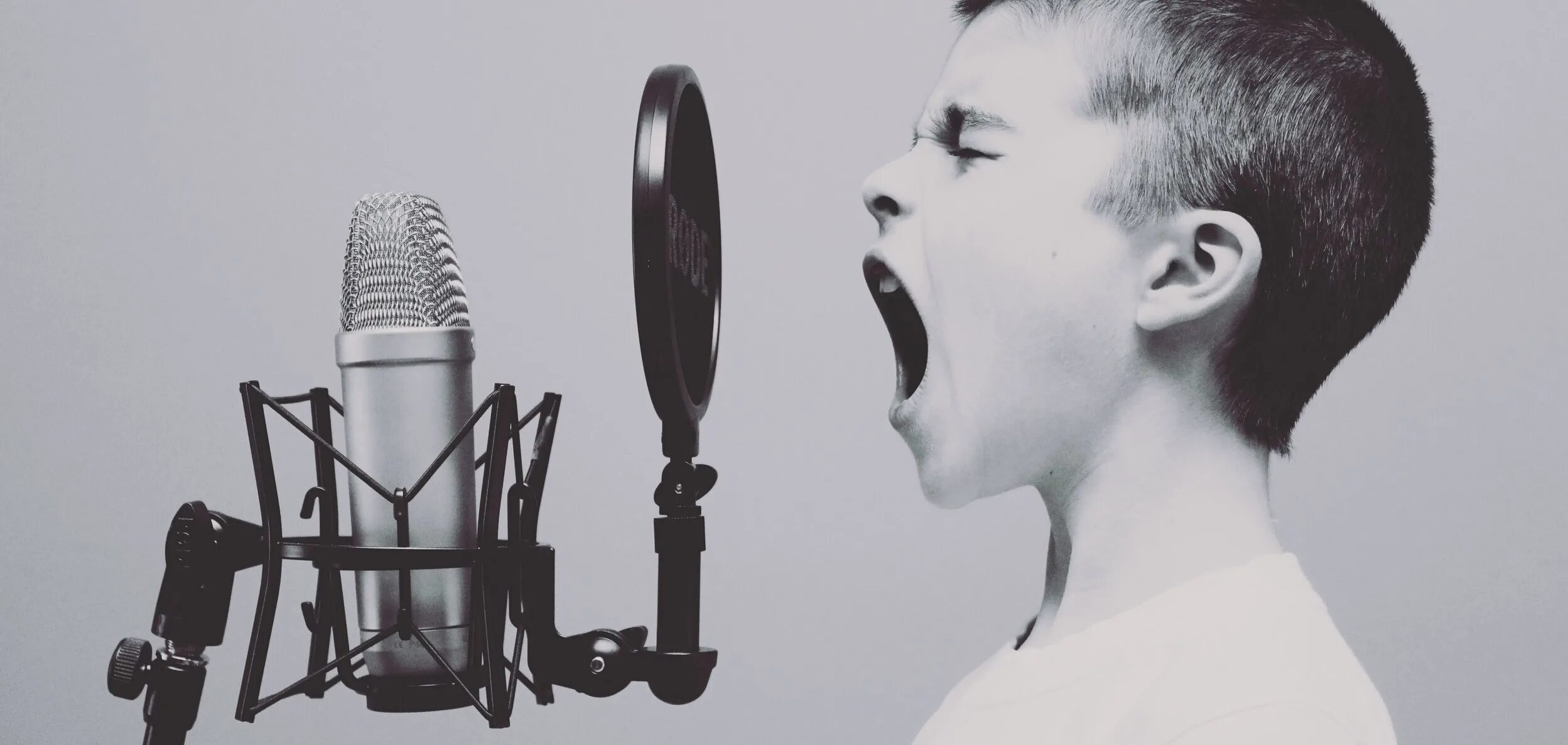 Вокализация речи. Ребенок с микрофоном. Человек перед микрофоном. Необычный голос. Человек кричит в микрофон.