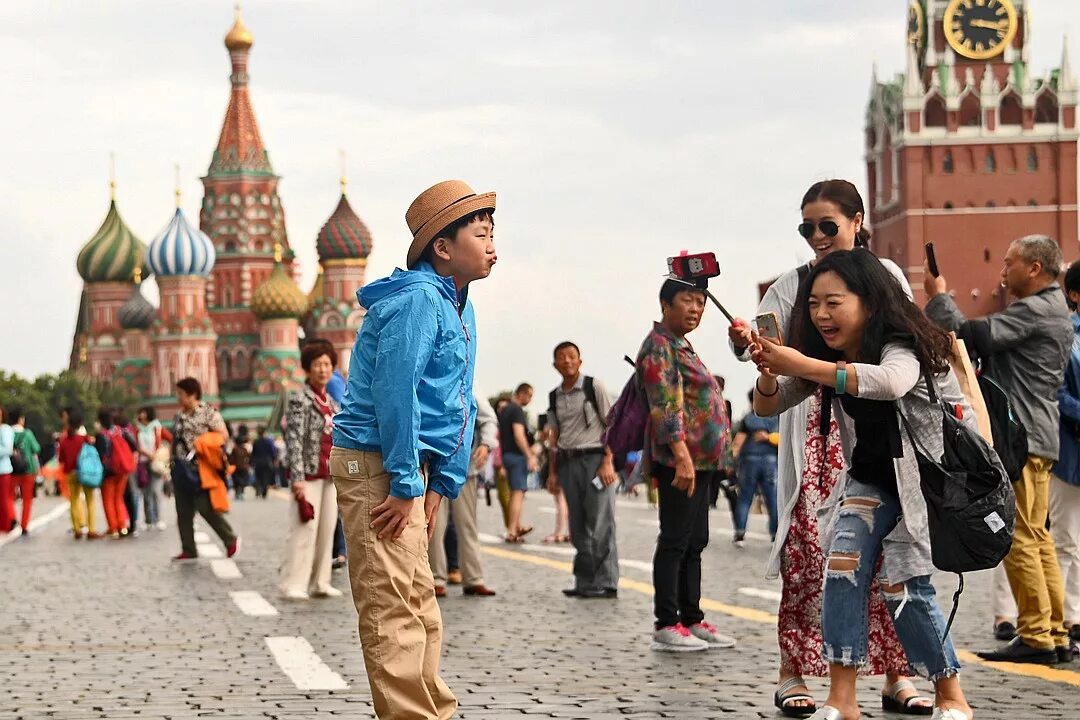Какие группы приезжали в россию. Туристы в России. Иностранные туристы в России. Туристы на красной площади. Китайские туристы.