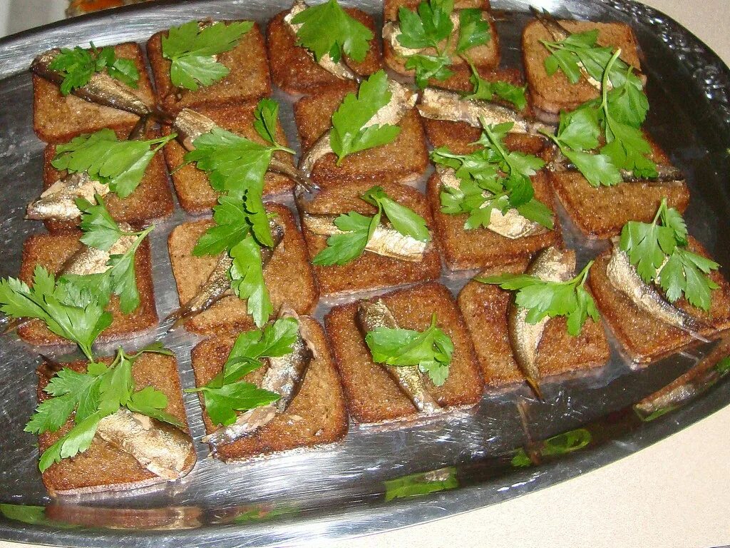 Треугольник из хлеба со шпротами. Гренки со шпротами. бутерброды с черным хлебом. гренки с чесноком и шпротами. бутерброды со шпротами на черном хлебе.